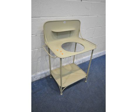 MARQUE DE FABRIQUE DEPOSEE, A FRENCH GREEN PAINTED METAL WASH STAND, the raised back with a small shelf, raised on cylindrica