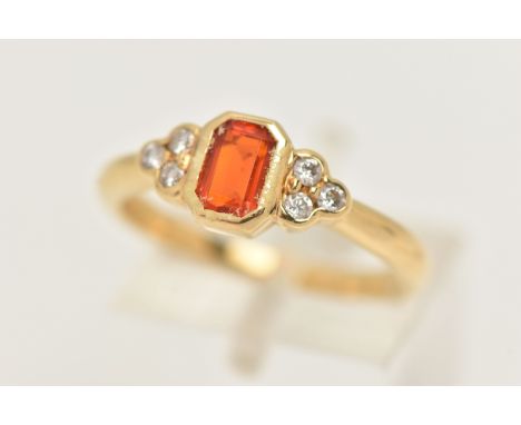 A MODERN 18CT GOLD FIRE OPAL AND DIAMOND DRESS RING, set with a principal rectangular step cut fire opal, measuring approxima