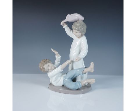 This Nao by Lladro figurine, titled Pillow Fight (#02001426), captures a playful childhood moment between two young boys enga