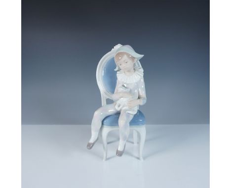 This Lladro figurine, titled Young Harlequin (#1001229), portrays a melancholic harlequin seated on a delicate blue chair, cr