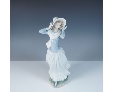 This Lladro porcelain figurine, item #1004936, captures the elegance of a young woman embracing the wind, her flowing dress a