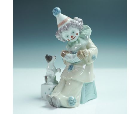 This glazed figurine features a whimsical Pierrot clown playing the concertina while a small dog attentively watches. It show