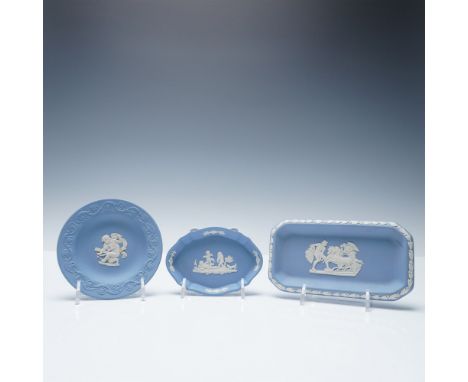 A collection of three Wedgwood blue jasperware trinket dishes, each adorned with classic white bas-relief designs. The set in