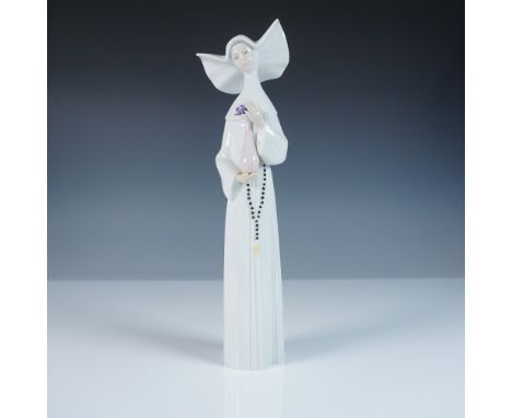 A striking Lladro porcelain figurine, model number 1005550, showcasing an elegant nun in flowing robes, delicately holding a 