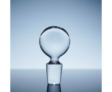 A finely crafted Baccarat crystal decanter stopper featuring a round, flat top with a tapered base. The stopper showcases Bac