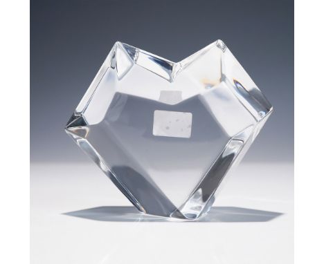 Crafted in clear crystal with angular faceted surfaces forming a heart-shaped silhouette. The design incorporates multiple ge
