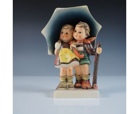 This Goebel Hummel figurine, titled Stormy Weather (#71), portrays two children huddled together under a large umbrella, brav