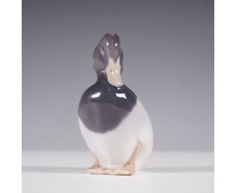 A Royal Copenhagen porcelain figurine of a tufted duck, exquisitely sculpted and hand-painted in naturalistic hues. The piece