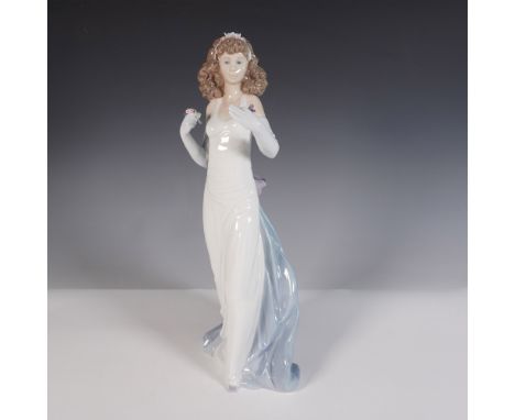 This elegant glazed figurine features a graceful woman in a flowing white gown with a soft blue draped sash cascading behind 