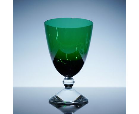 This elegant Baccarat Vega goblet features a striking green bowl atop a clear, geometrically faceted stem, exemplifying Bacca