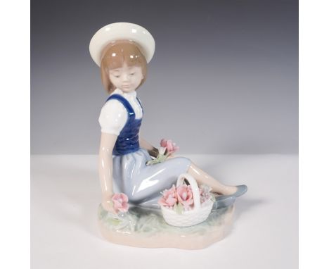 Charming hand-crafted porcelain figurine by Lladro, titled Picking Flowers (1001287). Sculpted by Francisco Catala, this sere