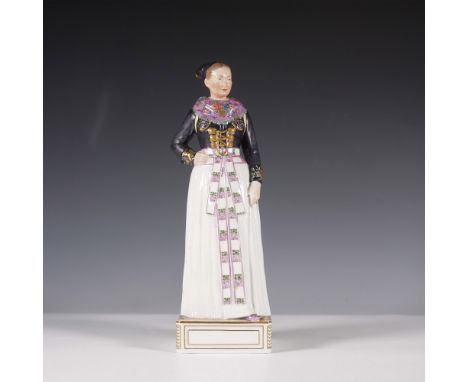 A beautifully crafted Royal Copenhagen porcelain figurine depicting a Danish woman in traditional regional attire. Featuring 