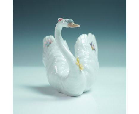 Delicate and refined, this Lladro porcelain figurine titled White Swan with Flowers, model number 1006499, was sculpted by Re