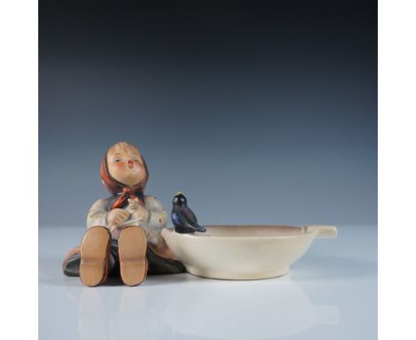 This vintage Hummel Happy Pastime Ashtray features a charming Goebel figurine of a young girl with a bird, sitting beside an 
