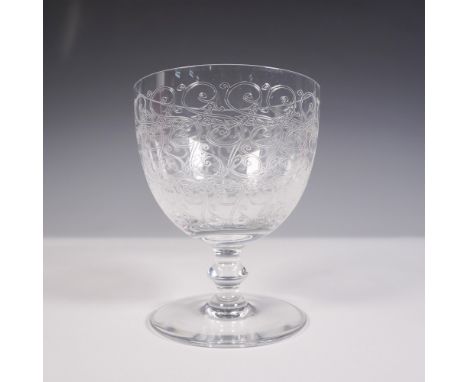 Etched crystal water goblet, features intricate scrollwork etched across the bowl and a clear wafer stem with a round foot. A