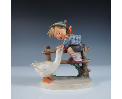 This Goebel Hummel figurine, titled Barnyard Hero (#195/1), portrays a charming scene of a young boy perched on a wooden fenc