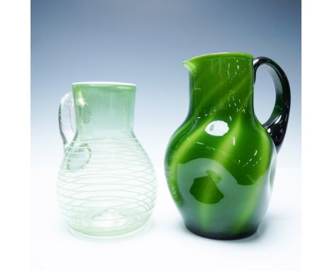 Captivating pair of handblown art glass pitchers, each showcasing a unique interplay of color and form. The first pitcher fea
