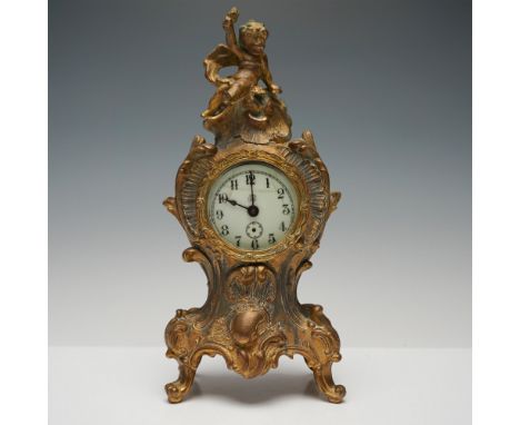Ornate gilt-bronze table clock by Jennings Brothers, featuring a Rococo-style case adorned with intricate floral motifs and a