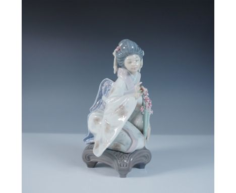 This Lladro figurine, titled Kiyoko (#1001450), depicts a serene geisha elegantly kneeling on a decorative base while holding