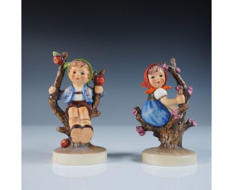 A delightful pair of Goebel Hummel figurines, featuring Apple Tree Boy and Apple Tree Girl. These beloved Hummel designs depi