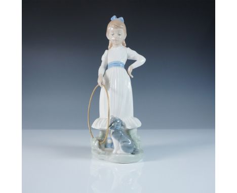 This Nao by Lladro figurine, titled My Dog Does Tricks, captures a charming scene of a young girl in a flowing white dress wi