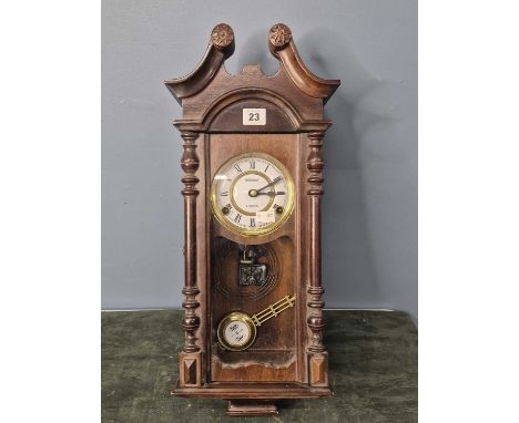 A Korean 'President' glazed mahogany wall clock striking on a coiled rod, the brass framed enamel disl with Roman numerals, t