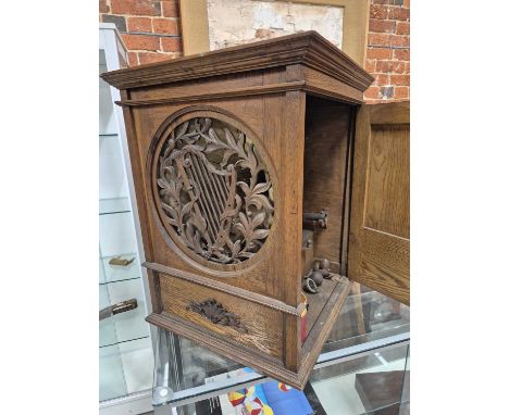 An unusual Horn gramophone with lever wind motor. The whole enclosed in an oak outer cabinet with a fret cut sound hole in th