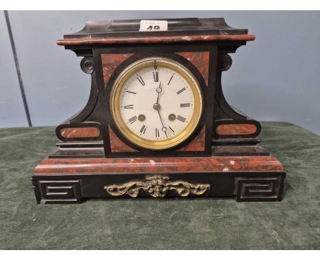 A mottled red marble trimmed black slate clock, the AEC movement striking on a bell, the white enamel dial above a brass wing