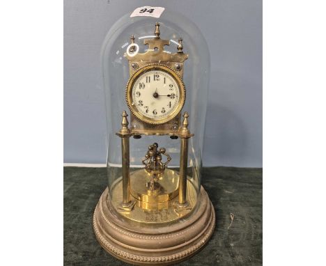 A rotary clock under a glass dome, the white face with Arabic numerals.   H 29cms.