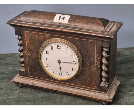 A mid 20th century oak cased mantel timepiece with a French platform escapement movement, the circular enamel dial with Arabi