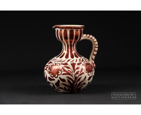 A Cantagalli ruby lustre onion form jug, decorated with flowering plants, blue painted mark, 14.5cm high