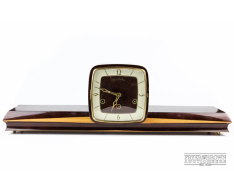 An Art Deco mantle clock , 66 cm long, shelf to either side of square face clock, Westminster eight day chime