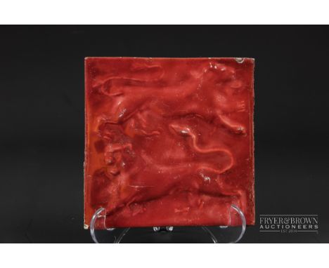 A William De Morgan red lustre tile, moulded with a double lion motif, impressed mark of Sands End pottery, Fulham, 15cm squa