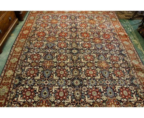 A Tabriz carpet, repeating abstract floral motif with stylised geometric border on a rust ground, 198 x 293cm approx.