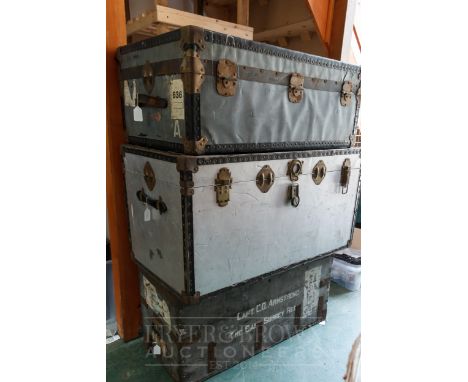 A large metal travelling trunk with reinforced corners and edging; a smaller trunk, similar; and a wooden trunk with lead lin