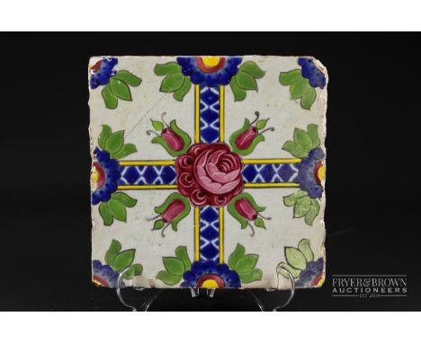 A Qajar tile, brightly glaze with a Damascus rose and four rose buds on crossed band, 19.5 square
