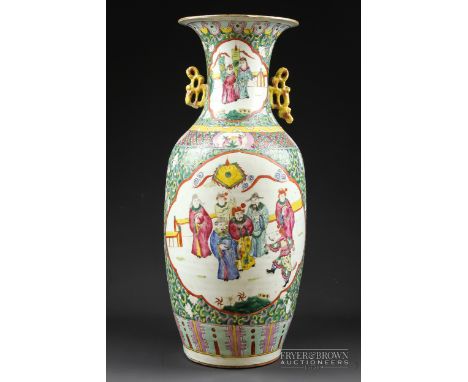 A large Chinese porcelain Canton enamelled vase, baluster form decorated with figures on a green 'C' scroll ground, 57cm high