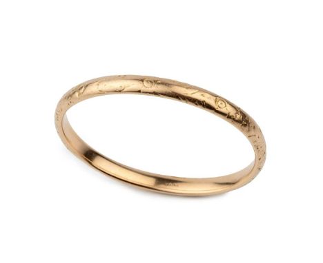 A 14k gold oval bangle, engraved with stylised flowers, stamped 14K, 7.5cm wideApprox 20.2g. Decoration quite worn