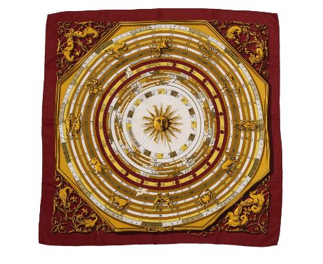 An 'Astrologie Forever' silk scarf by Hermès, designed by Françoise Faconnet, decorated in shades of claret and gold with a z