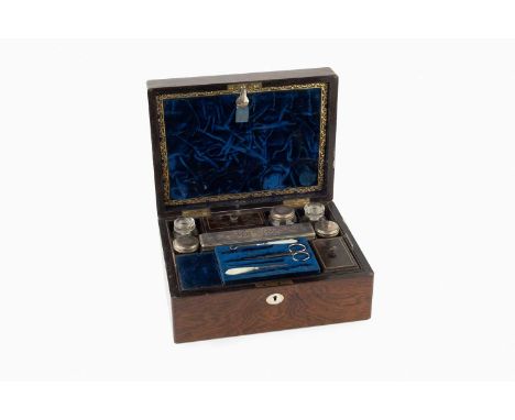 A Victorian rosewood toilet box, the fitted interior containing a range of bottles and jars with silver plated mounts, sewing