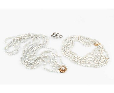 A triple strand freshwater pearl long necklace, the pierce-decorated 14k gold clasp of flowerhead form, centred with a split 