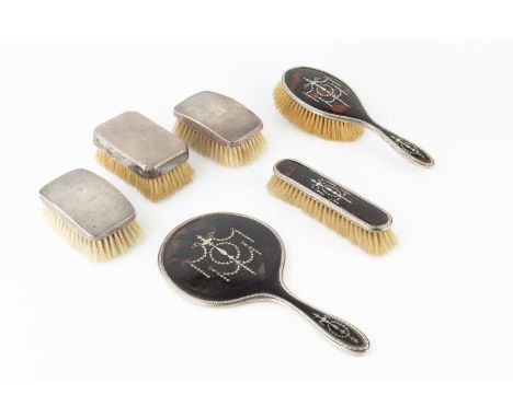 A George V silver mounted tortoiseshell backed dressing table set, comprising hand mirror, hair brush and clothes brush, Lond