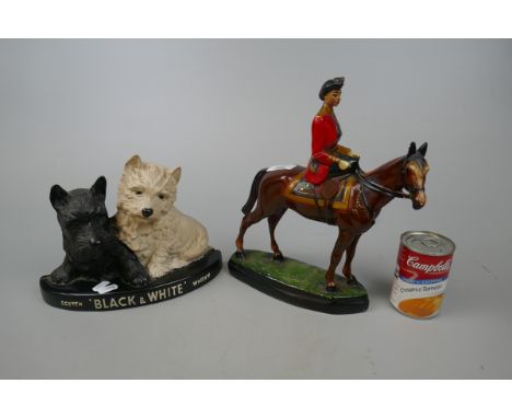 Figurine of the Queen riding a horse together with a Black and White Whisky figurine 