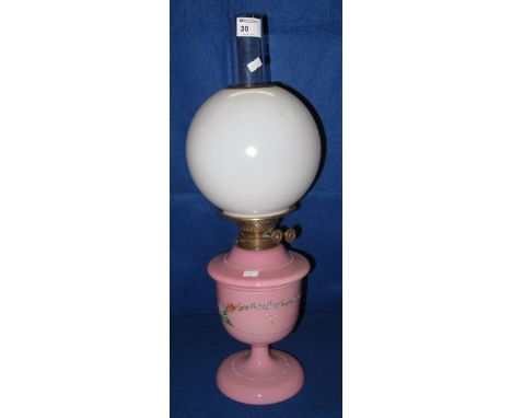 Brass double burner oil lamp with pink ceramic reservoir and pedestal base, painted with flowers and having white glass shade
