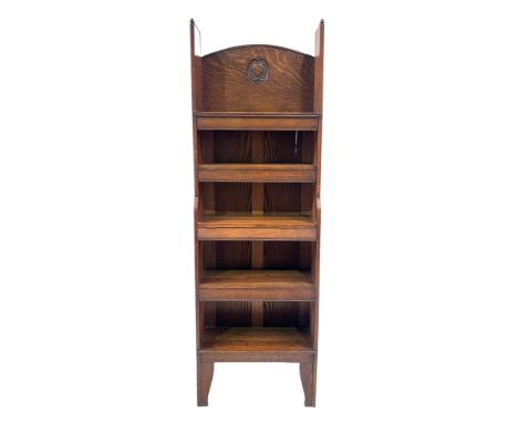 Arthur Simpson of Kendal, an Arts and Crafts oak five tier bookcase, the stepped panel sides with moulded arch tops, the arch