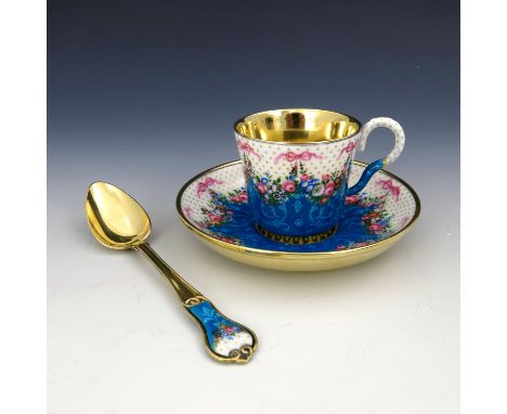 A French silver gilt enamel cabinet cup and saucer, early 20th Century, scroll handle, the exterior enamelled with swags of r