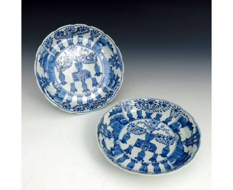A pair of Chinese blue &amp; white dished plates, wavy rims, decorated with vases of foliage and pagoda landscapes, blue four