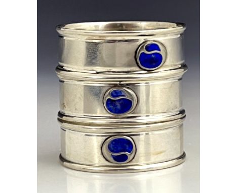 Charles Horner, a set of three Arts and Crafts silver and enamelled napkin rings, Chester 1923, each with a bisected bud roun