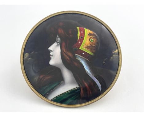 An Art Nouveau enamel convex plaque in the manner of Limoges, late 19th Century, decorated with a bust portrait of a young la