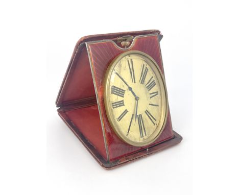 An easel travel timepiece, early 20th Century, red leather outer case, oval gilt dial with Roman numerals, red guilloche enam